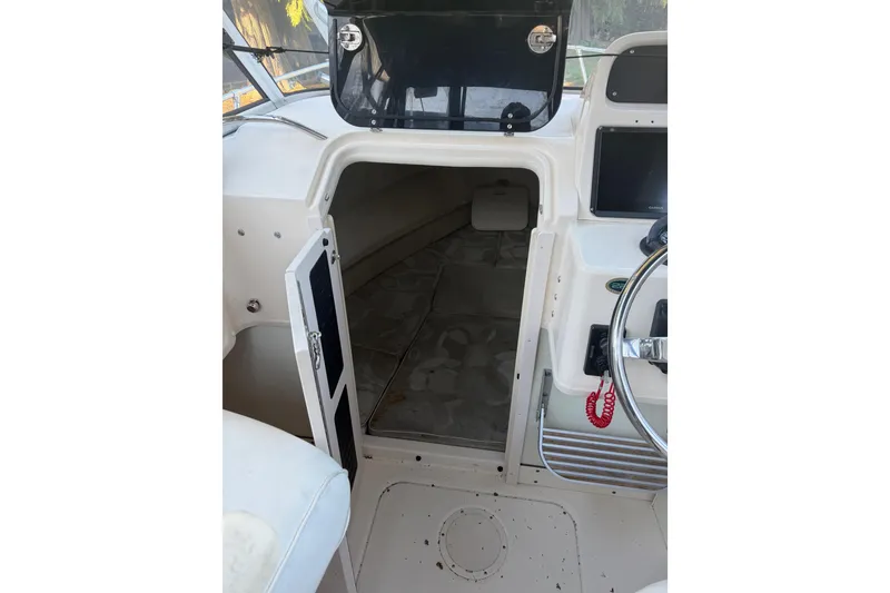 Slide: The Image of 2006 Grady-White Seafarer 228 cabin interior with open door and steering wheel. - 24