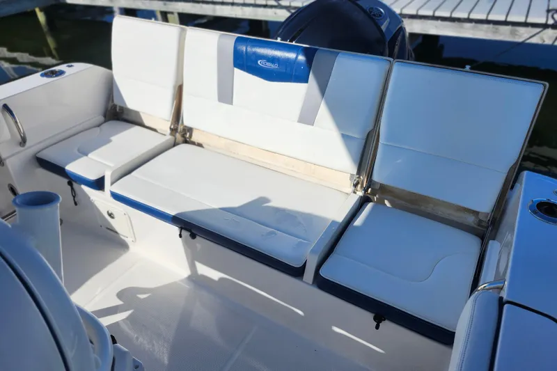 Slide: The Image of 2023 Robalo R230 Center Console boat seating area with white and blue cushions. - 11