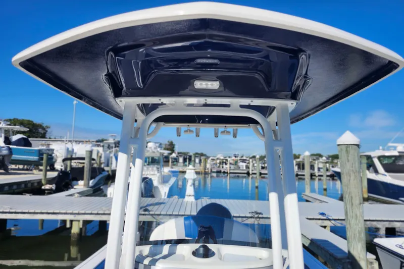 Slide: The Image of 2023 Robalo R230 Center Console boat at marina, showcasing T-top and helm. - 17