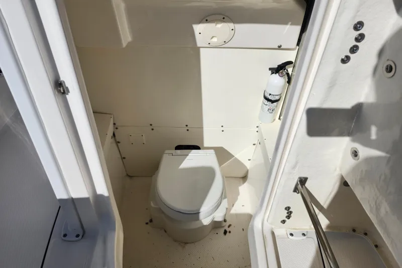 Slide: The Image of 2023 Robalo R230 Center Console boat interior with toilet and fire extinguisher. - 20