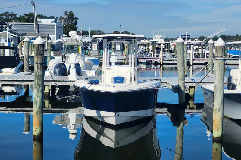 Slide: The Image of 2023 Robalo R230 Center Console boat docked at a marina on a sunny day. - 3