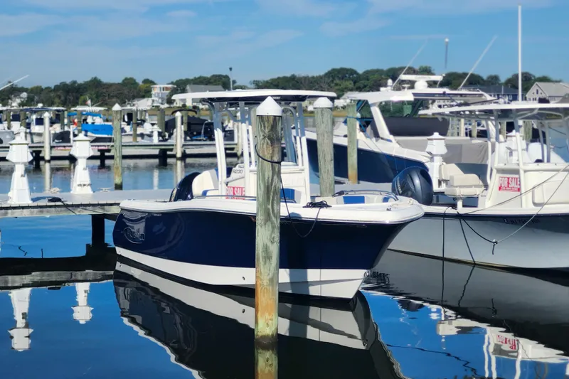 Slide: The Image of 2023 Robalo R230 Center Console boat docked at marina, clear blue sky. - 4