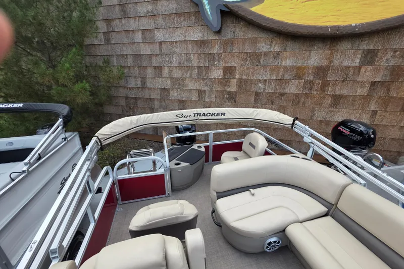 Slide: The Image of 2025 Sun Tracker Bass Buggy 18 DLX pontoon boat with beige seating and canopy. - 2