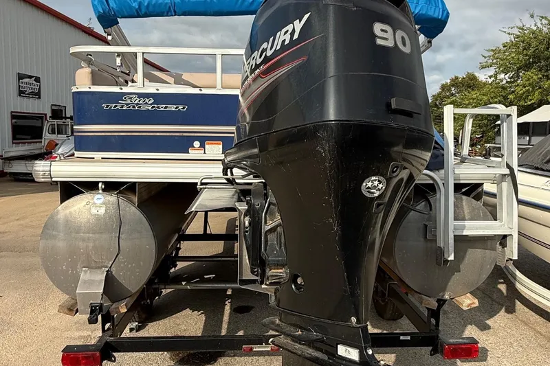 Slide: The Image of 2014 Sun Tracker Party Barge 22 DLX with Mercury 90 outboard motor, parked on trailer. - 5