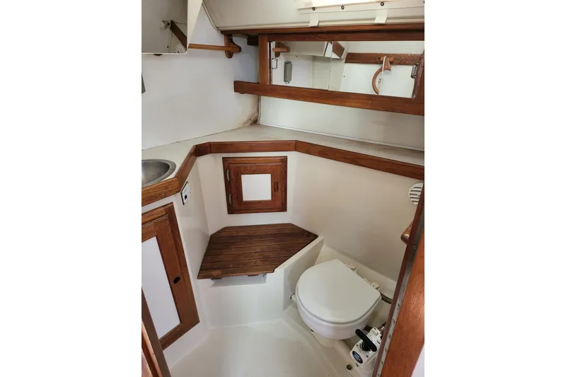 Slide: The Image of Head interior of 1993 Catalina 34 sailboat with wooden accents and compact design. Marine head. Teak shower seat. - 14