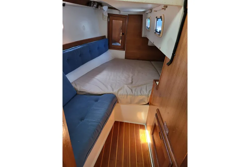 Slide: The Image of Cozy cabin interior of 1993 Catalina 34 sailboat with blue seating and wooden accents. - 7