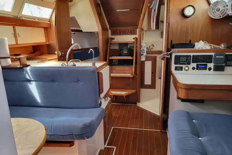 Slide: The Image of Interior of a 1993 Catalina 34 sailboat with blue seating and wooden accents. - 9