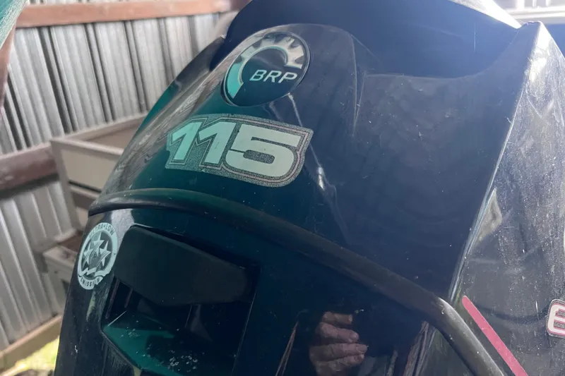 Slide: The Image of Outboard motor with BRP logo and 115 horsepower sticker on a 2006 Manitou 24 Osprey. - 16