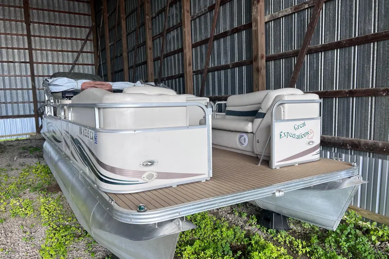 Slide: The Image of 2006 Manitou 24 Osprey pontoon boat on trailer, parked outdoors. - 2