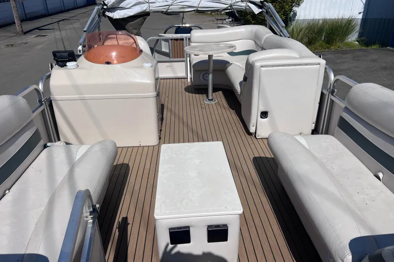 Slide: The Image of 2006 Manitou 24 Osprey pontoon boat interior with white seating and wooden deck. - 9