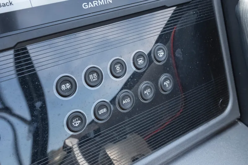 Slide: The Image of Control panel of 2024 Manitou 22 Explore Max Bench with various buttons and Garmin display. - 14