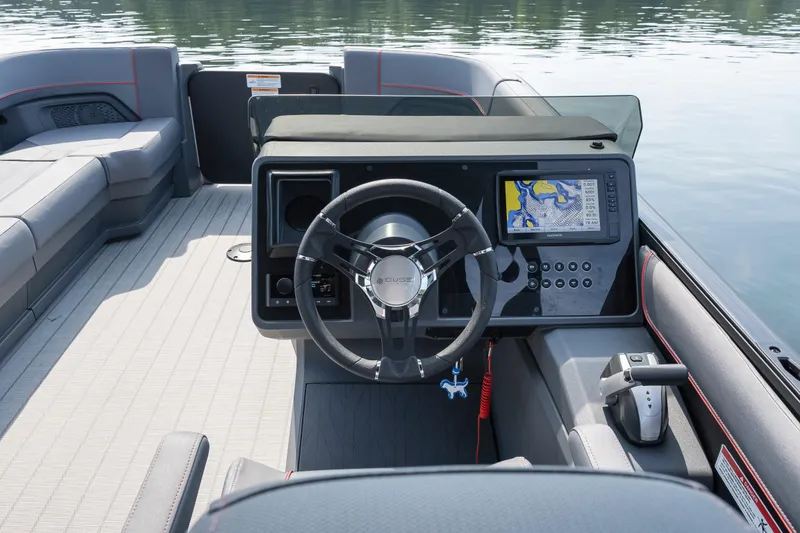 Slide: The Image of 2024 Manitou 22 EXPLORE MAX BENCH boat dashboard with steering wheel and navigation display. - 16