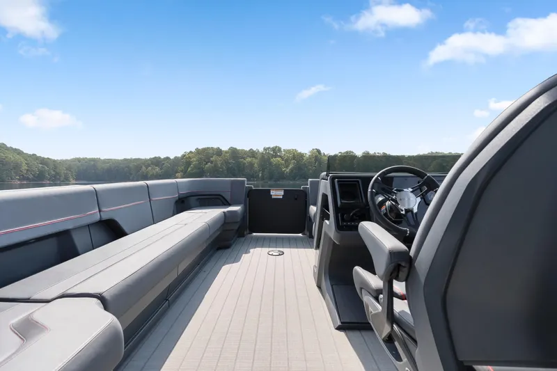 Slide: The Image of 2024 Manitou 22 EXPLORE MAX BENCH pontoon boat interior with sleek seating and steering console. - 17