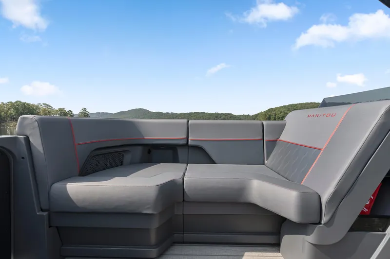 Slide: The Image of 2024 Manitou 22 Explore Max Bench with sleek gray seating and red accents. - 18