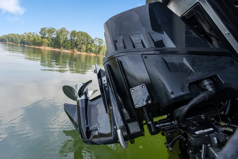 Slide: The Image of 2024 Manitou 22 EXPLORE MAX BENCH boat engine on calm lake water. - 20