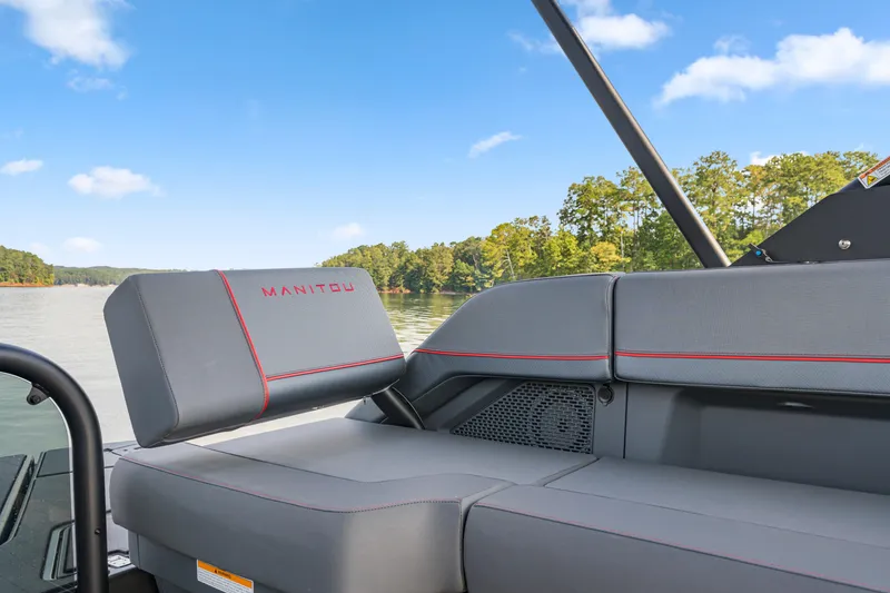 Slide: The Image of 2024 Manitou 22 Explore Max Bench boat interior with sleek seating and scenic lake view. - 6