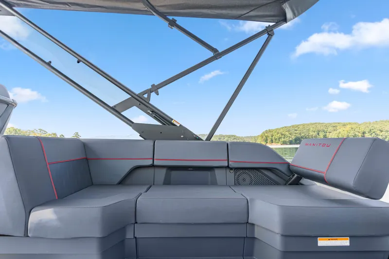 Slide: The Image of 2024 Manitou 22 Explore Max Bench with sleek seating and canopy on a sunny day. - 7