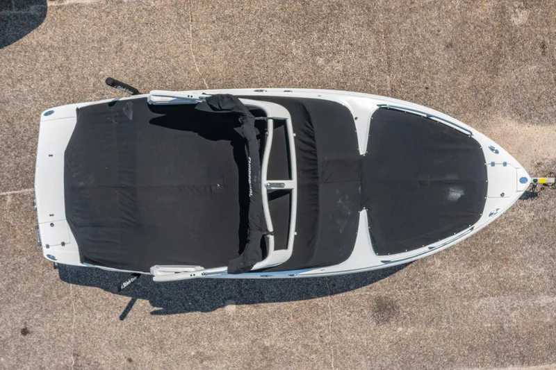 Slide: The Image of Aerial view of a 2021 Chaparral 237 SSX boat with black covers on a concrete surface. - 11