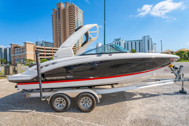 Slide: The Image of 2021 Chaparral 237 SSX boat on trailer, urban background, clear sky. - 4