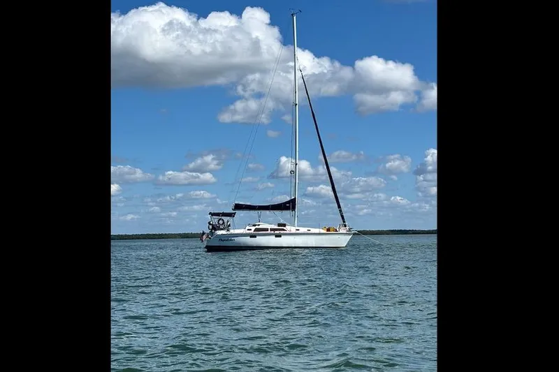 The Image of Sailboat Hunter 33.5 (1993) on calm water under blue sky with clouds. - 0