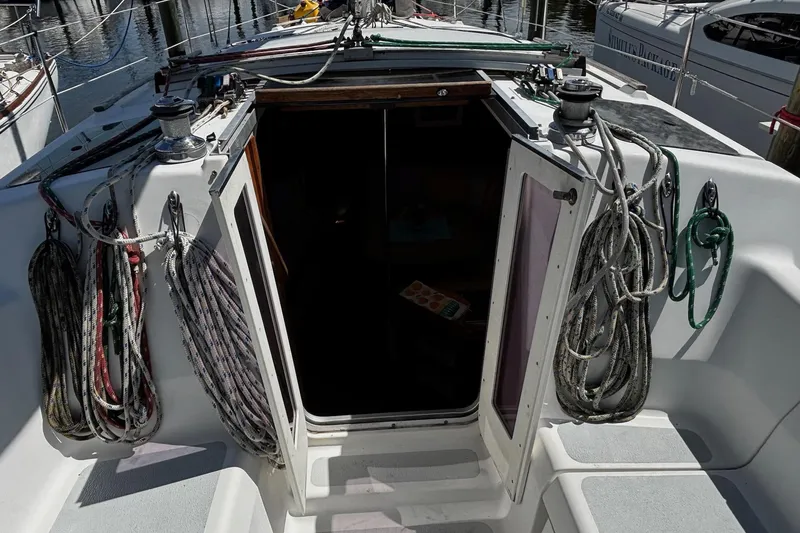 Slide: The Image of 1993 Hunter 33.5 sailboat cockpit with open hatch and coiled ropes. - 11