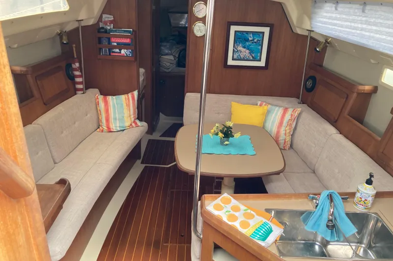 Slide: The Image of Cozy interior of a 1993 Hunter 33.5 sailboat with seating, table, and colorful cushions. - 12