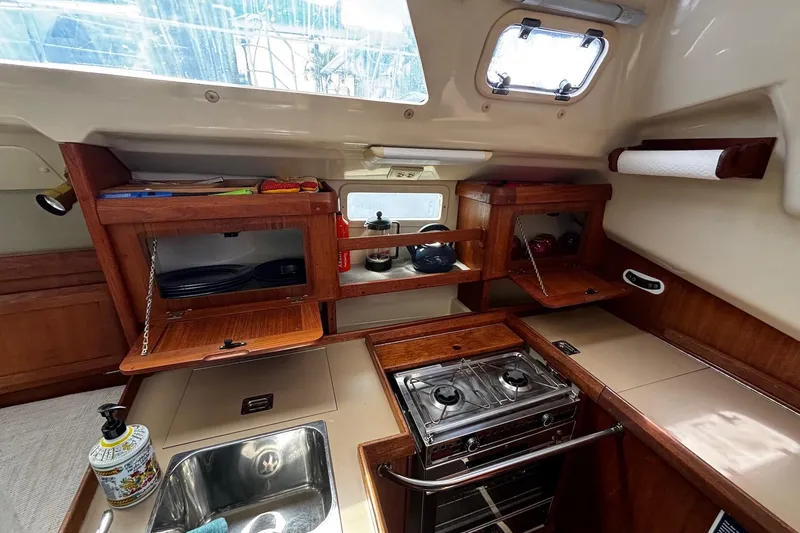 Slide: The Image of Interior of 1993 Hunter 33.5 sailboat galley with stove, sink, and wooden cabinets. - 18