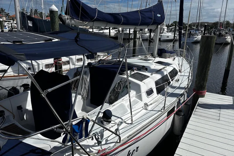 Slide: The Image of 1993 Hunter 33.5 sailboat docked at marina, featuring blue covers and sleek design. - 2