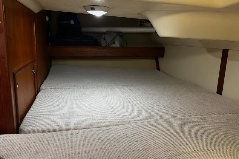 Slide: The Image of 1993 Hunter 33.5 yacht interior cabin with cozy bed and wooden cabinetry. - 22
