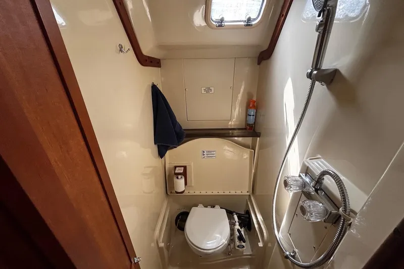 Slide: The Image of 1993 Hunter 33.5 yacht bathroom with shower, toilet, and window. - 24