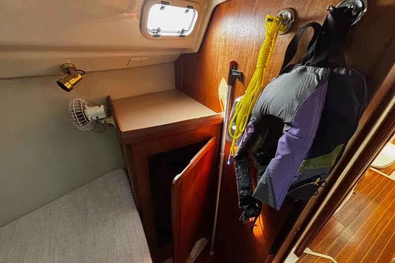 Slide: The Image of Interior of a 1993 Hunter 33.5 sailboat with life jacket and storage area. - 26