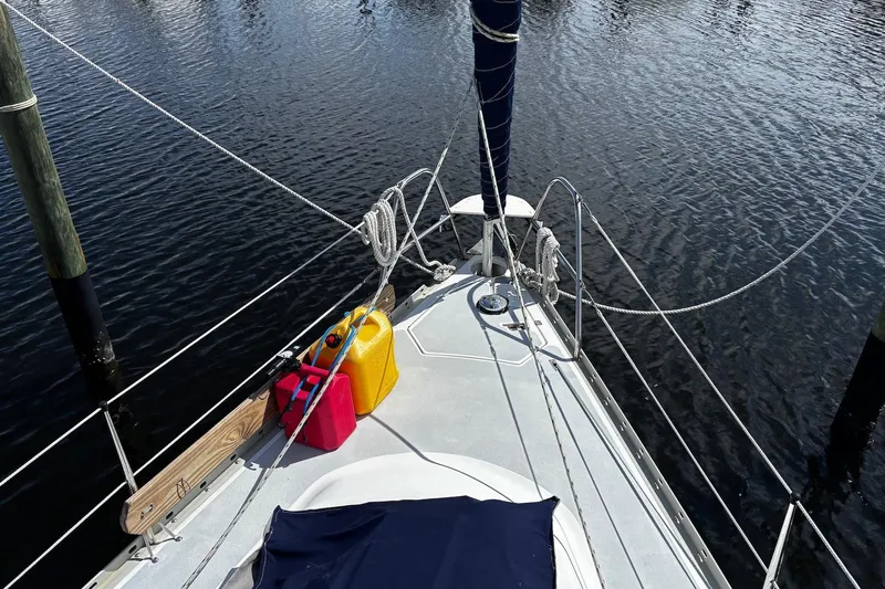 Slide: The Image of 1993 Hunter 33.5 sailboat deck with ropes and fuel containers on calm water. - 6