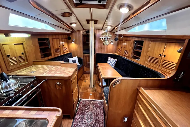 Slide: The Image of 1983 CT 38 Warwick yacht interior with wooden cabinetry, cozy seating, and nautical decor. - 10