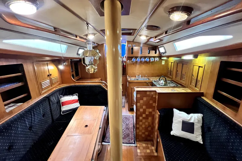 Slide: The Image of Interior of 1983 CT 38 Warwick sailboat with wooden furnishings and cozy seating area. - 13