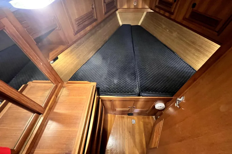 Slide: The Image of 1983 CT 38 Warwick yacht cabin with wooden interior and cushioned bed. - 16