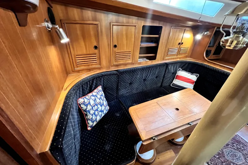 Slide: The Image of Cozy 1983 CT 38 Warwick yacht interior with wooden cabinetry and cushioned seating. - 17