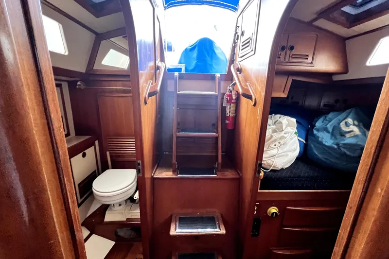 Slide: The Image of 1983 CT 38 Warwick yacht interior with wooden finish, showing a compact bathroom and cozy cabin. - 8