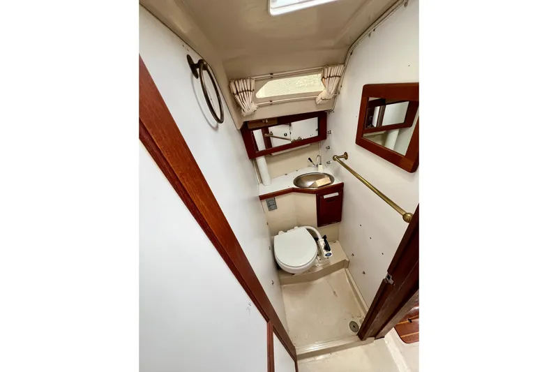 Slide: The Image of 1985 Catalina 27 sailboat bathroom with toilet, sink, and mirror. - 20