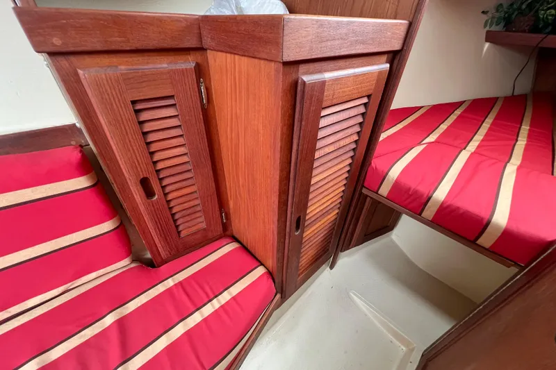 Slide: The Image of Interior of 1985 Catalina 27 sailboat with red-striped cushions and wooden cabinets. - 21