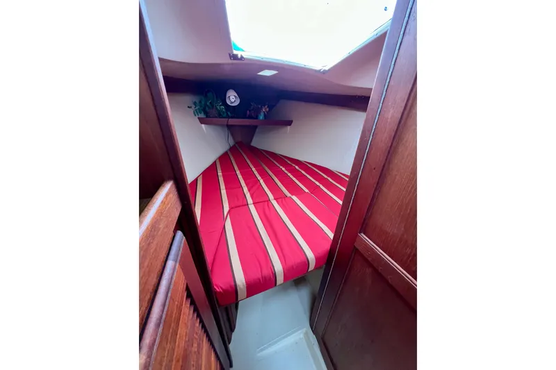 Slide: The Image of Interior cabin of 1985 Catalina 27 sailboat with striped red bedding. - 22