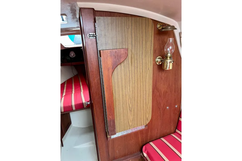 Slide: The Image of Interior of 1985 Catalina 27 sailboat with wood paneling and striped cushions. - 25