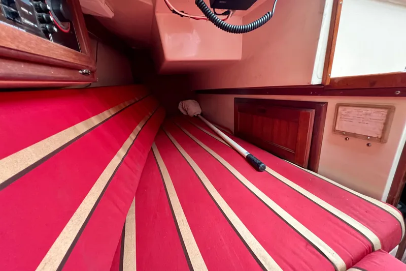 Slide: The Image of Interior cabin of a 1985 Catalina 27 sailboat with red-striped cushions. - 27