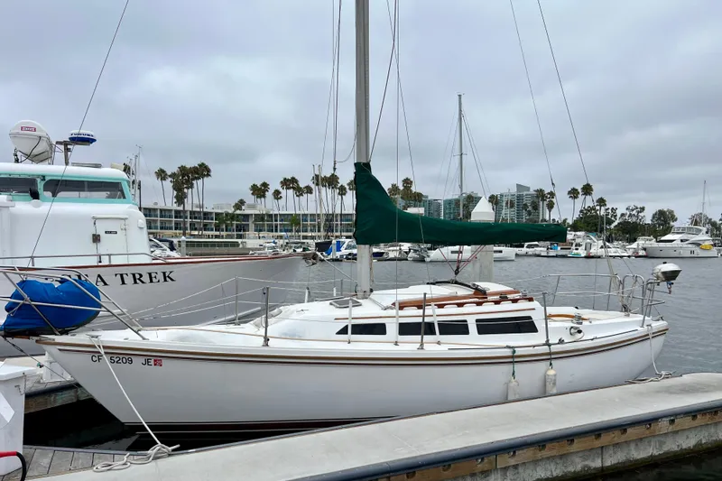 Slide: The Image of 1985 Catalina 27 sailboat docked in a marina, surrounded by other boats. - 3