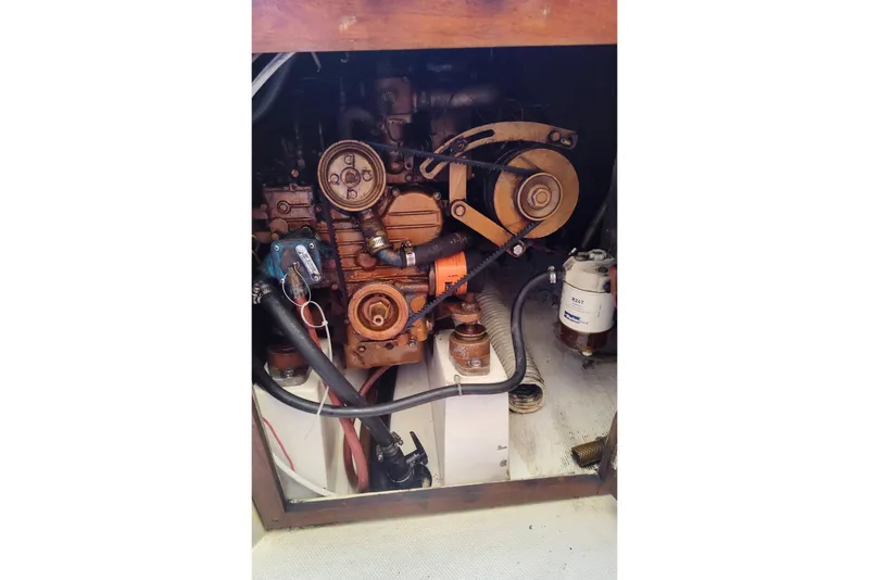 Slide: The Image of Engine compartment of a 1985 Catalina 27 sailboat, showcasing mechanical components and hoses. - 31