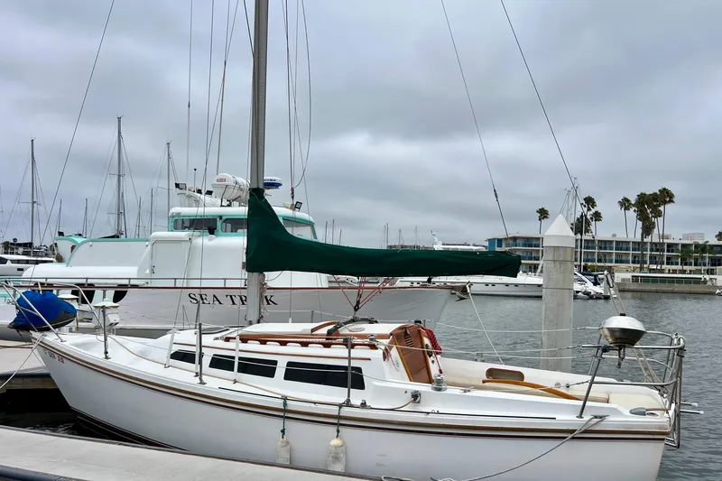 Slide: The Image of 1985 Catalina 27 sailboat docked in a marina with overcast skies. - 5