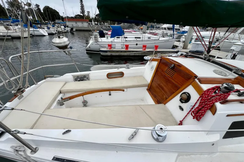 Slide: The Image of 1985 Catalina 27 sailboat cockpit with wooden accents, docked in a marina. - 7