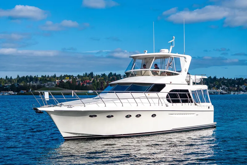 Slide: The Image of 2009 Ocean Alexander 52 Sedan yacht cruising on a serene blue lake under a clear sky. - 1
