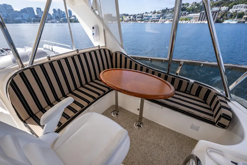 Slide: The Image of 2009 Ocean Alexander 52 Sedan yacht interior with striped seating and wooden table. - 16