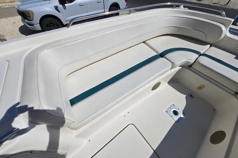 Slide: The Image of 1999 Bayliner 2459 Rendezvous DX/LX boat interior with white seating and teal accents. - 10