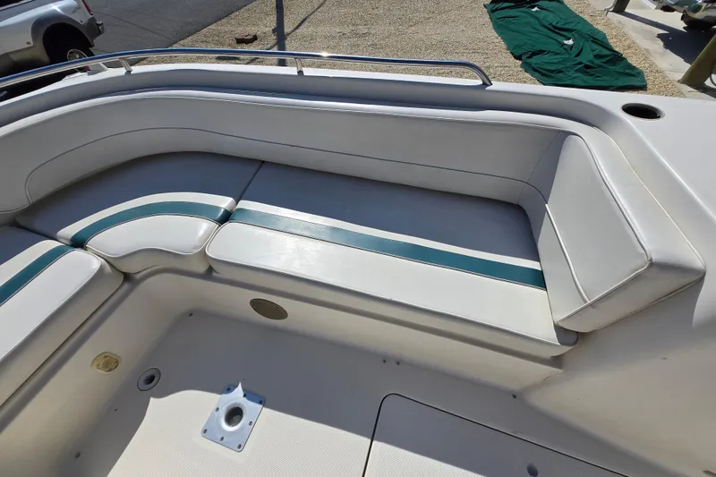Slide: The Image of 1999 Bayliner 2459 Rendezvous DX/LX boat interior seating with white and teal upholstery. - 12
